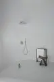 Dusche mit Wandanschluss, halbkreisförmiger Duschbereich und minimalistischer Ablage. Ideal Standard, edles Design und funktionale Elemente in einem modernen Raum.